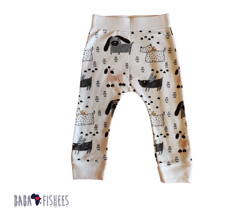 A pair of cuffed pants featuring a comfortable fit with cuffs at the ankles, with colourful illustrations of various dogs, along with patterns scattered throughout the design.