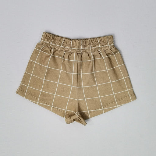 A pair of light brown shorts made from waffle fabric, featuring a textured pattern. The shorts have an elastic waistband and a simple, comfortable design.